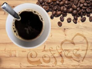 coffee-beans-on-white-ceramic-mug-beside-coffee-beans-on-brown-wooden-table-1-300x225